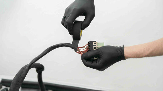 A engineer is taping the wire harness with Vinyl black tape
